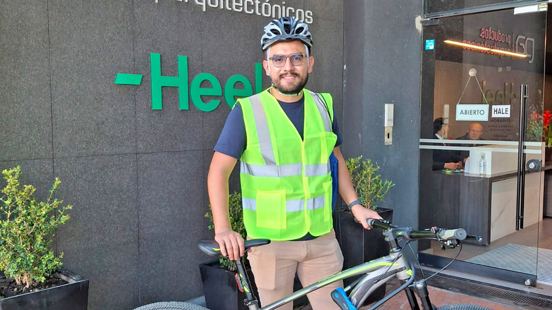 Heel Kolumbien Mitarbeiter steht mit Fahrrad vor Heel-Eingang.